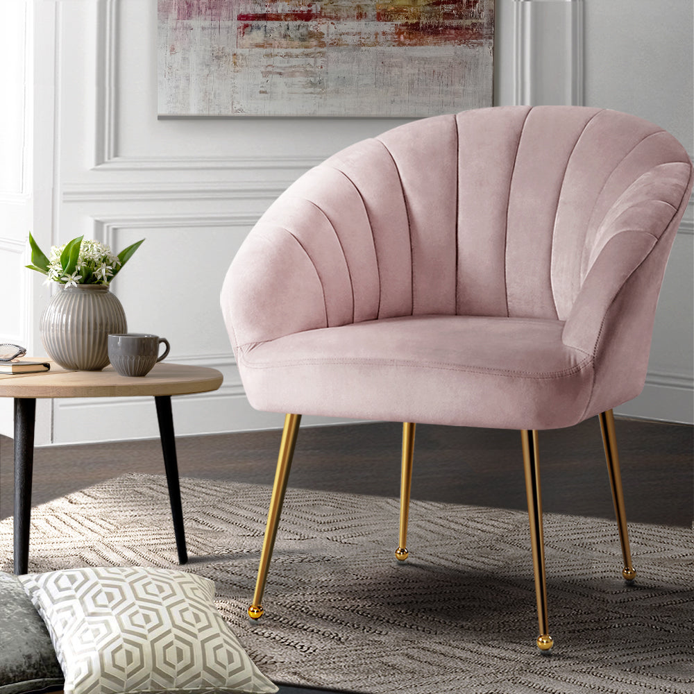 Light Pink Bar Sofa Chair with metal legs placed in a living room with cushions and a side table.